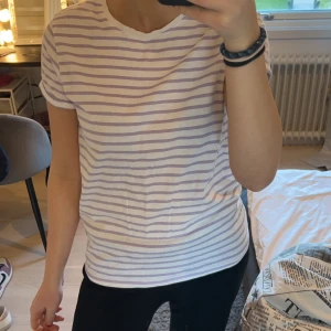 Vit och lila randig t-shirt från FSBN Sister - Säljer en superfin vit och lila randig t-shirt från FSBN Sister. Den är i storlek S och har en klassisk rund halsringning. Perfekt för vardagsbruk och passar till allt! 💜 Knappt använd!