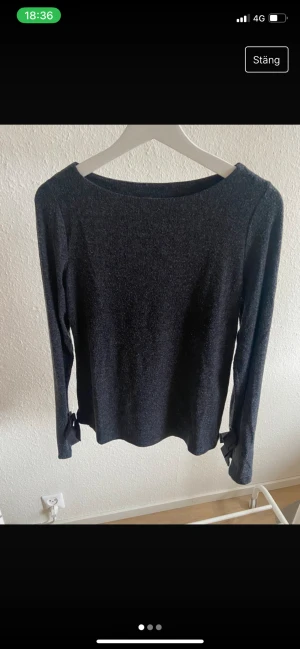 Tröja - Grå tröja med bred urringning och detaljer vid handlederna. Storlek S