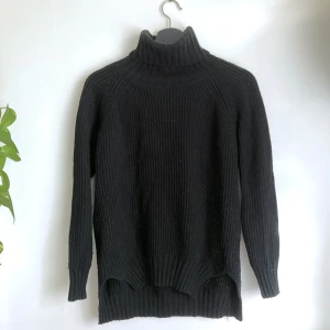 Svart grovstickad polo tröja, S 36/38, ull, långärmad, stilren, enkel, klassisk, chunky - Svart grovstickad polotröja i ullblandning, små slitsar i sidorna. Tecken på användning i form utav noppor. Storlek: S, bröstvidd: 54 cm, längd fram från axeln: 60 cm, ärmlängd mätt från ringningen: 62 cm.