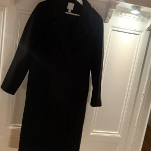 Svart halvlång kappa  - Obetydligt använd endast 2 gånger  Inköpt vinter 2023 nypris 799 säljes för 350 Det är en xs/s men passar en m oxå 