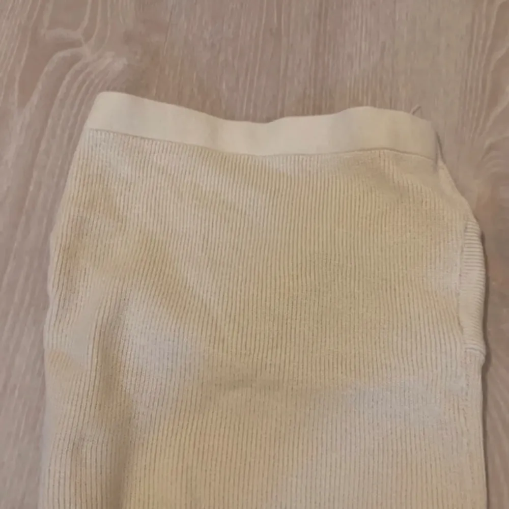 Säljer en superfin beige ribbad tubtopp med en snygg twistdetalj framtill. Perfekt för sommardagar eller en utekväll. Toppen är i ett mjukt och stretchigt material som sitter bekvämt. Passar bra till både jeans och kjol!. Toppar.