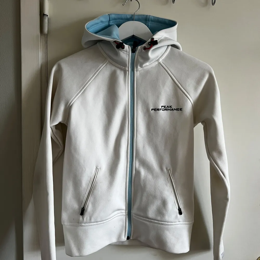 Vit peak performance huvtröja med zip. Använd några gånger. Några skavanker med små fläckar (se två sista bilderna). Hoodies.