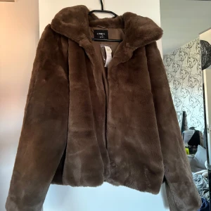 Brun pälsjacka - Säljer min pälsjacka från Lindex (fuskpäls) som är helt oanvänd med prislapp kvar. Ordinarie pris 899kr, säljer för 300kr. 