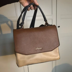 Puccini väska ”vintage” - Fin väska från Puccini. Lite vintage stil. Bra med plats utan att kännas för stor. Kan ha den som både handväska och axelremsväska då remmen går att ta av.  Fräscht skick! 🤍 #handväska #axelremsväska #vintage #puccini #beige #blå #guld #brun