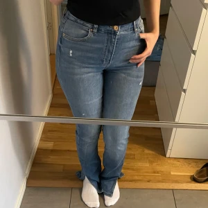 Blå jeans med bootcut och slit - Säljer ett par snygga blå jeans med bootcut från Bershka. Jeansen har en lätt slitning för en trendig look och har en slits längst ner. De är helt i nycksick,aldrig använda då de är för långa för mig som ni kan se, jag är 164💕🌸 de har en del stretch och är i storlek 38.(Jag brukar ha ungefär S)