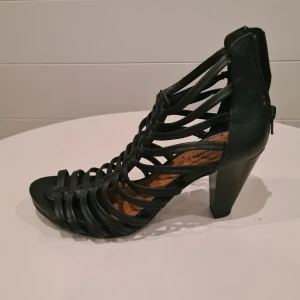 Svarta högklackade sandaler - Snygga svarta klackskor med remmar och dragkedja bak. Väldigt lite använda. Litet skav bak på ena hälen.