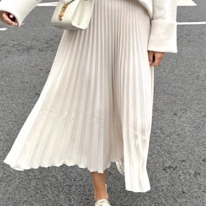 Veckad kjol från H&M - Beige plisserad / veckad kjol från H&M i storlek S. Ofodrad. Ljus beige / cremevit  Som ny - endast använd en gång.