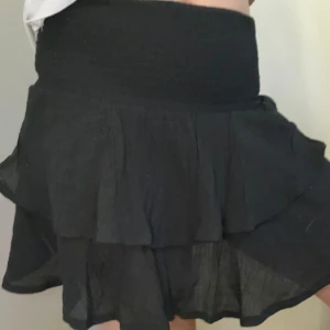 Kjol - En svart kort volang kjol, kan även användas som topp, i fint skick. Endast använd ett fåtal gånger 💕 Storlek: S
