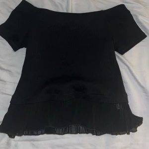 Off shoulder topp - Säljer denna slutsålda svarta off shoulder topp från zara med detalj längst kanten där nere. Använd kanske 5 gånger, köpt i Barcelona förra året. Hör av er för fler bilder.