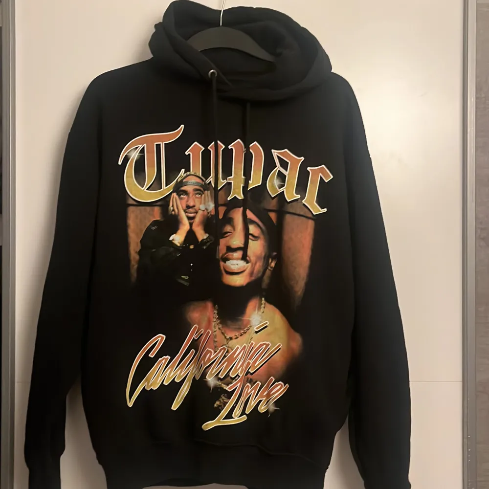 En hel svart hoddie med tupac tryck på framsidan. Sitter lite oversize, perfekt inför hösten. Tröjan går att stila både för män och kvinnor. Ena snöret har skadats o därför säljer jag hoddin billigare än vad jag köpt den för.. Hoodies.