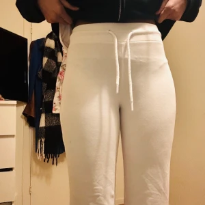 Vita mjukisbyxor med snörning - Säljer ett par vita mjukisbyxor med snörning i midjan. Byxorna har en bekväm passform och är perfekta för en avslappnad stil. De är högmidjade och gjorda i ett mjukt material som känns skönt mot huden.