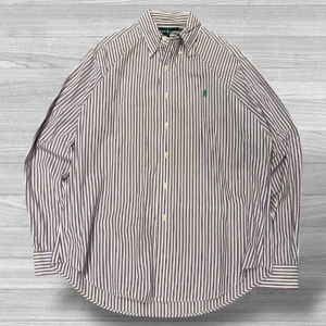 Ralph Lauren skjorta - Säljer en stilren randig skjorta från Ralph Lauren i storlek L. Skjortan har en klassisk krage och knappar framtill. Den är vit med lila ränder och har en broderad grön logotyp på bröstet. Perfekt för en snygg och avslappnad stil.
