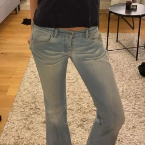 Ljusblå bootcut jeans från Diesel - Snygga ljusblå bootcut jeans från Diesel med klassisk femficksdesign. Jeansen har en bekväm passform och är perfekta för en avslappnad stil. Märkesdetaljer syns på fickan och knapparna.