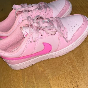 Rosa Nike sneakers - Säljer ett par rosa Nike sneakers med ljusrosa och mörkrosa detaljer. Skorna har snörning och en klassisk Nike-logga på sidan. Perfekta för en sportig look. Knappt använda priset går att diskuteras vid snabb affär 