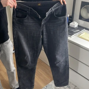 Svarta jeans från Lee - Snygga svarta jeans från Lee med en klassisk femficksdesign. De har en dragkedja och knapp framtill. Perfekta för en avslappnad stil med en rak passform. HELT NYA använde 1 vecka sen fick jag ett annat par byxor 