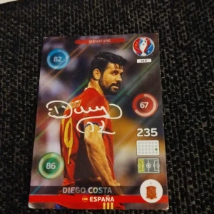 Fotbollskort med Diego Costa - Säljer ett fotbollskort från Panini med Diego Costa i den spanska landslagströjan. Kortet är en del av UEFA Euro 2016-kollektionen och har en signatur. Perfekt för samlare av fotbollsmemorabilia! Pris kan diskuteras!