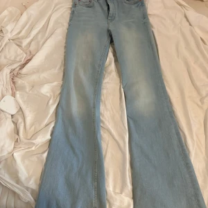 Ljusblå jeans från Zara - Snygga ljusblå jeans från Zara med bootcut-stil. De har en klassisk femficksdesign och är perfekta för en avslappnad look. Jeansen är tillverkade i ett bekvämt denimtyg. ALDRIG ANDVÄNT. Haft i gaderobben i så länge men hadde aldrig på mig den.