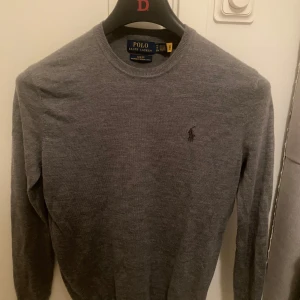 Grå merinoull tröja  från Ralph Lauren - Säljer en stilren grå tröja från Ralph Lauren i slim fit. Tröjan är 9,5/10 nyskick andvänd endast 3-5 gånger.