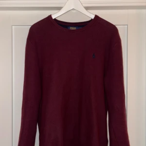 Vinröd tröja från Polo Ralph Lauren - Säljer en stilren vinröd tröja från Polo Ralph Lauren med broderad logotyp på bröstet. Tröjan har långa ärmar och är tillverkad i ett mjukt material som passar perfekt för kyligare dagar. Perfekt för dig som vill ha en klassisk look!                     Nypris (2100kr).                                                                Storlek M