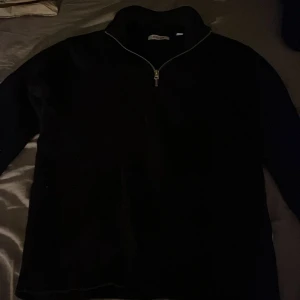 Svart tröja med dragkedja från Only & Sons - Säljer en stilren svart tröja från Only & Sons. Tröjan har en praktisk dragkedja framtill och är perfekt för både vardag och avslappnade tillfällen. Den är tillverkad i ett bekvämt material som håller dig varm. Använd en gång!!