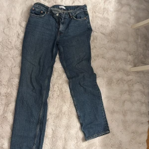 Blå jeansbyxor - Raka blåa jeans från Gina. Sitter tajt vid låren och lösare där nere. 