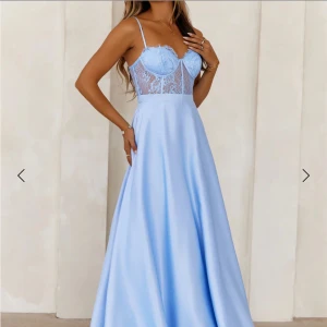 Ljusblå långklänning med spetsdetaljer - Elegant ljusblå långklänning med spetsdetaljer på överdelen och tunna axelband. Klänningen har en vacker v-ringning och en dragkedja i ryggen. Perfekt för bal. Köpte den från hellomolly i stl m men valde en annan klänning. Betalde även en del frakt. 