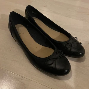Svarta ballerinaskor med rosett - Säljar ett par svarta ballerinaskor som nya. Glansiga och söta. Strl 39 men passar nog 38. Pris går att diskutera 💖