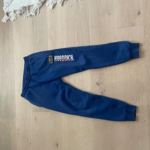 Blå mjukisbyxor från Hoodrich - Snygga blå mjukisbyxor från Hoodrich med tryck på benet. Extremt bekväma och perfekt för en skön outfit!