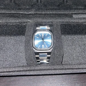 Silverfärgad klocka från Faucon - Stilren klocka från Faucon med silverfärgad boett och armband. Urtavlan är Tiffany blue med lysande visare och index, perfekt som första klocka eller om du bara vill utöka din samling. Klockan har en modern och elegant design som passar till många tillfällen.