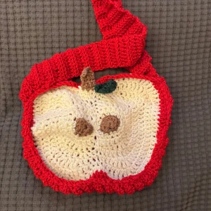 Handgjord äppelformad axelväska - Unik handgjord axelväska i form av ett äpple. Väskan är virkad i rött och beige med detaljer i brunt och grönt. Virkad av mig. (Kan även virka annat på beställning) pris går att diskutera