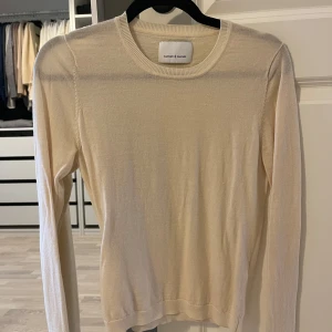 Krämfärgad tröja från Samsøe Samsøe - Säljer en stilren och mjuk krämfärgad tröja från Samsøe Samsøe. Tröjan har en rund halsringning och långa ärmar, perfekt för en minimalistisk look. Passar bra till både jeans och kjol. Perfekt för alla säsonger!