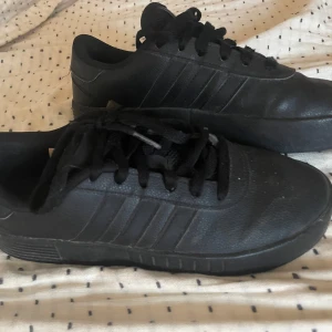 Svarta sneakers från Adidas - Snygga svarta sneakers från Adidas med klassisk design och snörning. I storlek 37 1/2