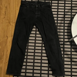 Svarta jeans från Jack & Jones - Snygga svarta jeans från Jack & Jones med en relaxed passform. De är använda men syns inte! Nypris ca 700, mitt pris: 129kr! hör av dig vid funderingar/ mer bilder😃