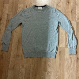 Grå Stickad Tröja Från Bruun&Stengade  - Nu säljer jag denna riktigt stilrena tröja i stickat material från märket Bruun&Stengade. Tröjan är väl omhändertagen dvs mycket fint skick. (Passar bäst från 170-180). Skriv gärna vid frågor. :)