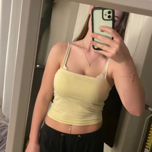 Gult linne från Gina Tricot - Säljer ett sött linne från Gina Tricot. Toppen har smala axelband och en enkel design som passar perfekt till sommaren. Perfekt för en avslappnad look!💛💛🏖️☀️