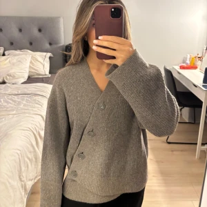 Grå ribbad kofta med knappar - Säljer denna super fina kofta från & other stories som tyvärr inte kommer till användning. Lappen med storleken är tyvärr bortklippt men skulle säga att det är storlek S