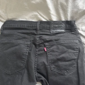 Svarta jeans från Levi's - Snygga svarta jeans från Levi's Premium. Klassisk femficksdesign med knappgylf och bälteshällor. Perfekta för en stilren look.