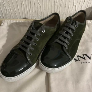 Gröna sneakers från Lanvin - Snygga gröna sneakers från Lanvin med en kombination av mocka och glansigt material på tån. Dustbags ingår. UK 8. Nya helt oanvända. 2700kr