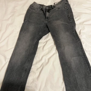 Grå jeans från  HM - Snygga grå jeans från HM  med en klassisk femficksdesign. De har en dragkedja och knapp framtill. Perfekta för en avslappnad stil.