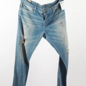 Blå jeans från Polo Ralph Lauren - Snygga blå jeans från Polo Ralph Lauren med slitna detaljer och hål på framsidan. Perfekta för en avslappnad stil.