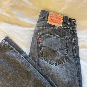 Grå Levis 505 jeans - Klassiska grå Levis 505 jeans med rak passform. Det finns en liten reva på benet, men den syns knappt när jeansen är på. Pris kan diskuteras vid snabb affär. 