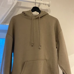 Grön Hoddie - Bik Bok - En jättefin hoodie med luva och snören. Den är i nyskick då den har använts max tre gånger. Den är tillverkad av ett mjukt och skönt material med innertyg som är fodrat. Den har en oversized passform, vilket gör den både bekväm och mysig. Perfekt för vintern, då den är väldigt varm🤍