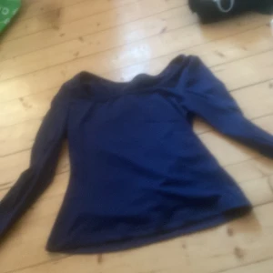 Mörkblå offshoulder topp - Snygg mörkblå offshoulder topp med långa ärmar. Perfekt för en stilren look.