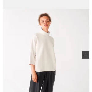 Vit polotröja med trekvartsärm - Elegant beige polotröja med trekvartsärm. Perfekt för en stilren och minimalistisk look. Tröjan har en lös passform och är tillverkad i ett mjukt material som ger en bekväm känsla.