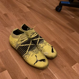 Fotbollsskor - Snygga gula fotbollsskor från Puma med svarta detaljer och snörning. Perfekta för fotbollsplanen med sin iögonfallande design och funktionella passform. Den är i jätte bra skick har knappt använts, köpte dom för 900. Storlek 42,5 sitter jätte bra