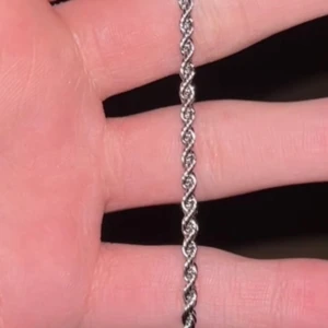 Silverfärgat flätat armband - Snyggt silverfärgat armband med flätad design. Perfekt för att ge en stilren touch till din outfit. Armbandet har en smidig låsmekanism som gör det enkelt att ta på och av.