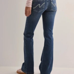 Blå bootcut jeans från Nelly - Snygga blå bootcut jeans från Nelly med snygga bakfickor. Dom är lågmidjade och bra i längden på mig som är runt 170💞Kom gärna med prisförslag