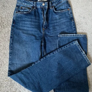 Blå jeans från NA-KD - Snygga blå jeans från NA-KD i klassisk femficksmodell. De har en hög midja och raka ben. Tillverkade i slitstarkt denim med knapp och dragkedja framtill. Jätte fina och mycket bra skick 