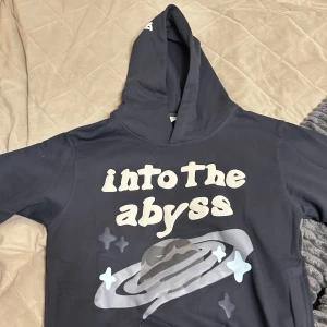 ”Into the abyss” broken planet hoodie - Säljer en hoodie med texten 'into the abyss' och ett coolt rymdmotiv på framsidan. Tröjan har en stor luva och långa ärmar, perfekt för en avslappnad stil. Dock är den lite cropped villet inte passade mig och därför säljee jag den. Den är helt ny och dm för mer info.                          PRISET KAN DISKUTERAS!