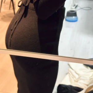 Svart stickad kjol - Snygg svart stickad kjol med lång ärm och knytband i midjan. Perfekt för kyligare dagar med sin bekväma passform och stilrena design. Midi kjol passar perfekt för s/m/l storlek